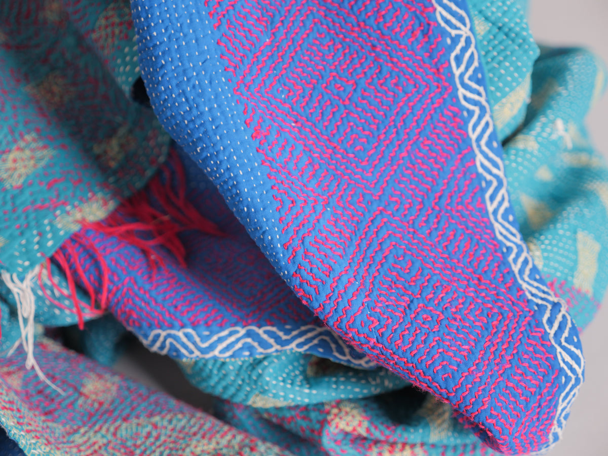 Couverture kantha brodé main, fond bleu.