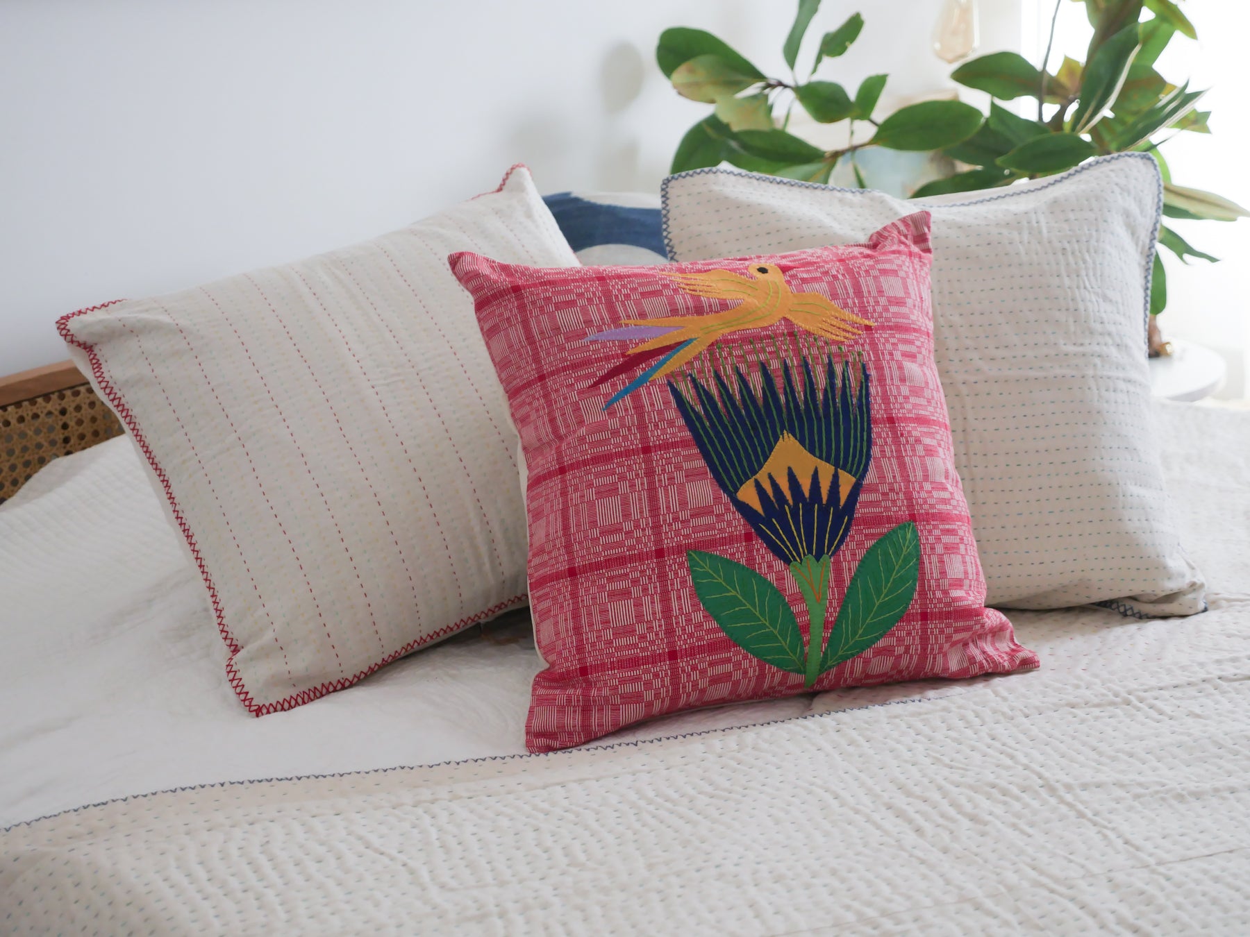 Hand loomed cushion with applique embroidery.