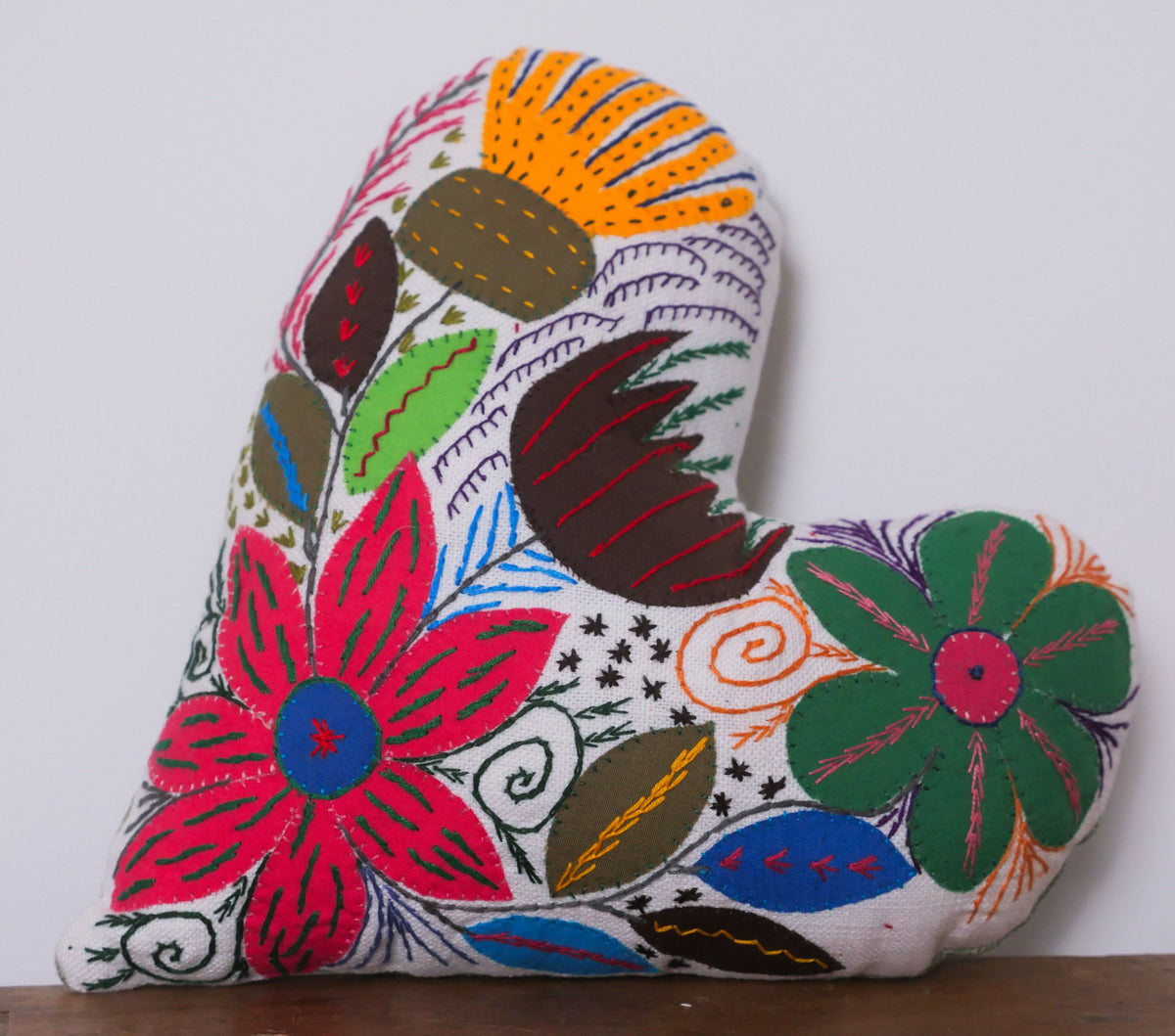 Heart shaped cushion, hand embroidered by a women's association in Cape Town.
