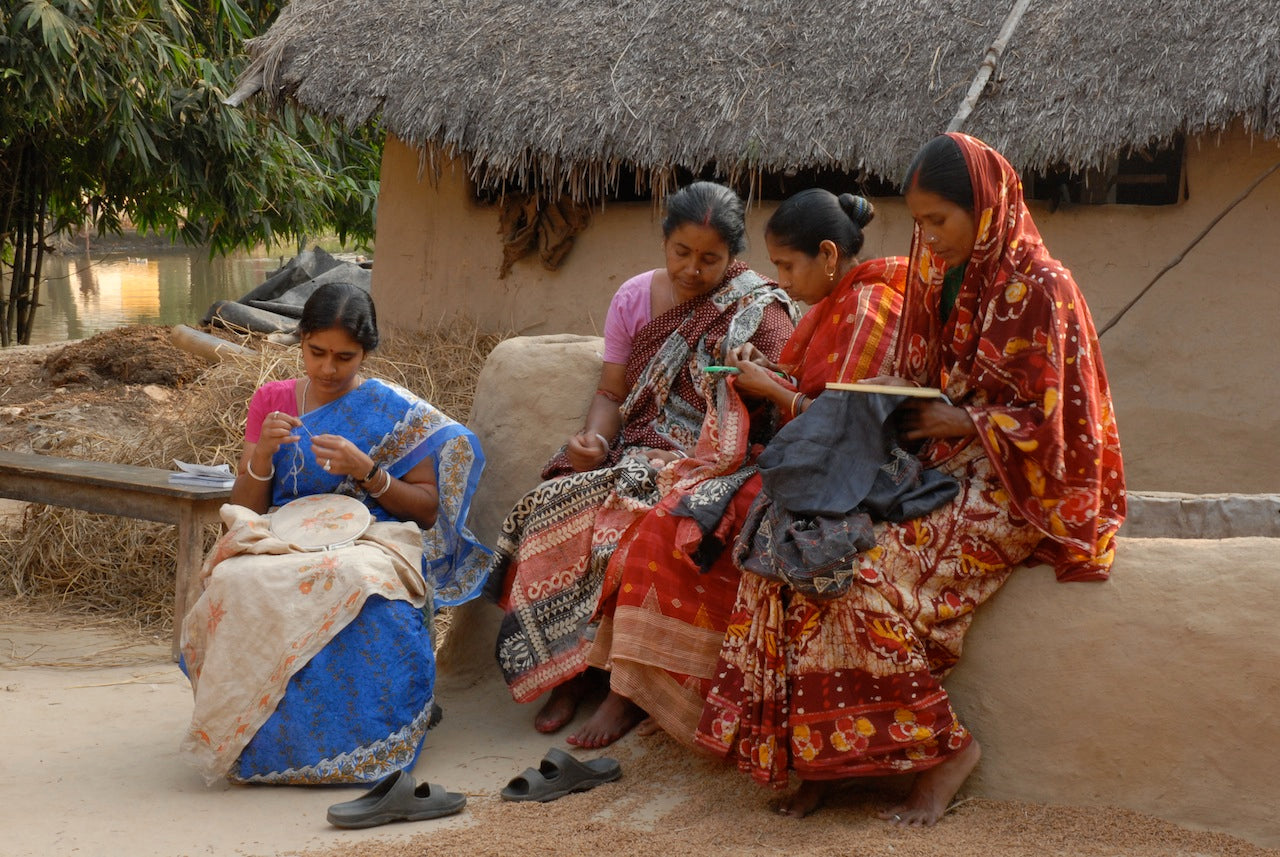 Women artisans working on kantha embroidery.
